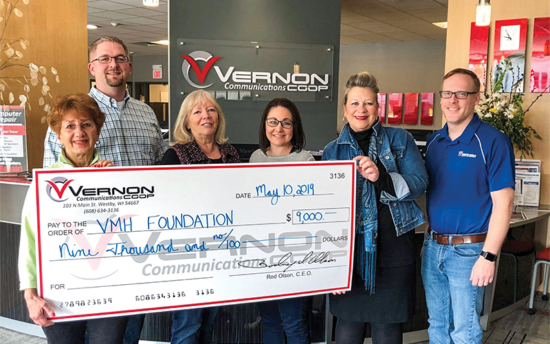 Vernon Communications holding a giant check made out to VMH Foundation